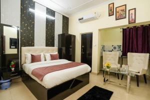 a bedroom with a bed and a table and a chair at Ventex Inn in Lucknow
