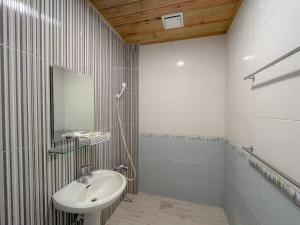 uma casa de banho com um lavatório e um espelho em Golden Coast 36 - Sea View B&B em Nanwan