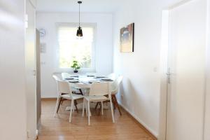 a dining room with a table and white chairs at beautiful 3-room apartment in Wetzlar