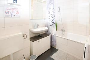 a white bathroom with a sink and a bath tub at beautiful 3-room apartment in Wetzlar