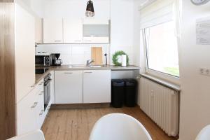 a small kitchen with white cabinets and a sink at beautiful 3-room apartment in Wetzlar