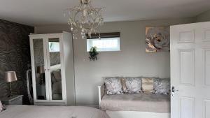 a bedroom with a bed and a chandelier at Runway Cottage in Coningsby +21 photos