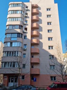 een hoog appartementencomplex met een schaduw aan de zijkant bij Nerva Traian Studio in Boekarest