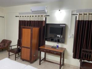 um quarto de hotel com uma televisão e uma mesa com uma mesa sidx sidx em UPPERCREST RESIDENCY PALA em Pala