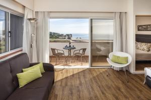 - un salon avec un canapé et une vue sur l'océan dans l'établissement Pestana Alvor Atlantico Residences Beach Suites, à Alvor
