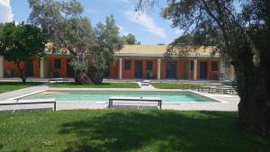 a swimming pool with benches in front of a building at Seadrop Suites in Lefkada