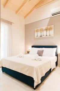 a white bedroom with a large bed in a room at Seadrop Suites in Lefkada +27 photos