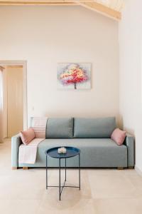 Seadrop Suites في ليفكادا تاون: غرفة معيشة مع أريكة وطاولة