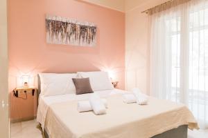 um quarto com uma grande cama branca com almofadas brancas em Seadrop Suites em Lefkada
