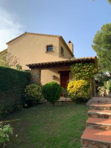 una casa con un patio de hierba delante de ella en Magnifique Villa avec vue mer 8 personnes, en Llafranc