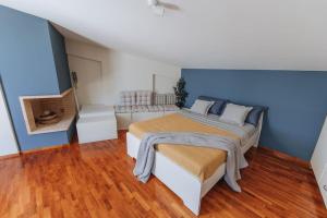 um quarto com uma cama e um sofá em Varkiza Escape - Amazing Home only 500m from Beach em Vári