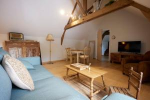 uma sala de estar com um sofá azul e uma mesa em Gîte à la ferme 4 à 6 personnes. em Vieille-Chapelle