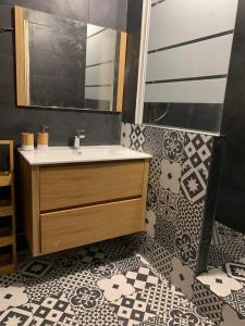 a bathroom with a sink and a tile floor at Superbe maison, confort calme et pratique in Cergy