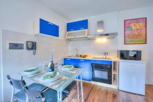 a kitchen with blue cabinets and a table with chairs at Casa Umberto - Happy Rentals in Tenno