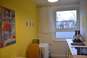 a yellow kitchen with a sink and a window at F2 - Am alten Elbarm - Laubegast in Dresden +11 photos