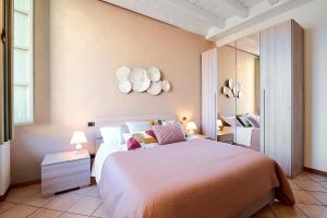 sypialnia z dużym łóżkiem i lustrem w obiekcie Domus Dea Città Alta w Bergamo