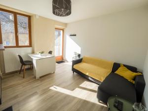 sala de estar con sofá y mesa en Charmant T2 avec terrasse et place de parking, en Aix-les-Bains