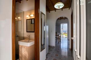 un baño con lavabo y espejo en Stegna Silence Seaview, en Archangelos 16 fotos más