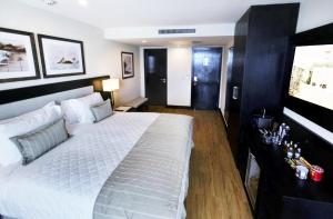 a bedroom with a large white bed and a television at Miramar By Windsor Copacabana in Rio de Janeiro