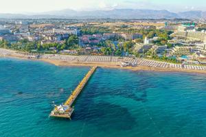 ein Pier im Wasser neben einem Strand in der Unterkunft Arum Barut Collection - Ultra All Inclusive in Side