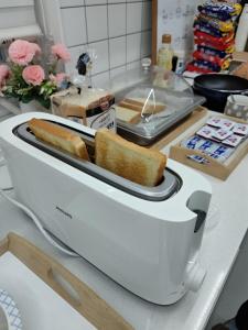 a toaster on a counter with two slices of bread at Athene Motel in Gwangju