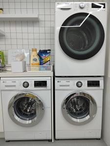 - deux lave-linge et un lave-linge/sèche-linge dans la cuisine dans l'établissement Athene Motel, à Gwangju