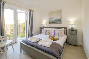 a bedroom with a bed and a large window at The Garden Flat in Aldeburgh