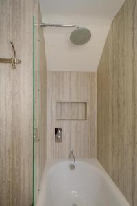 a bathroom with a bath tub and a shower at The Garden Flat in Aldeburgh