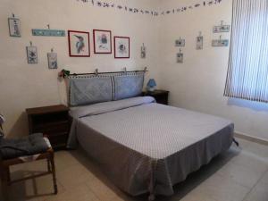 a bedroom with a bed and pictures on the wall at Casa Lore al mare in Santa Lucia
