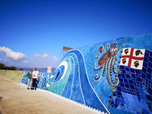 two people standing next to a wall with a mural at Casa Lore al mare in Santa Lucia +6 photos