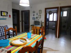 a living room with a table and a television at Casa Lore al mare in Santa Lucia