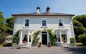 a white house with tables and chairs in front of it at Glenmore House B&B Mullingar in Mullingar