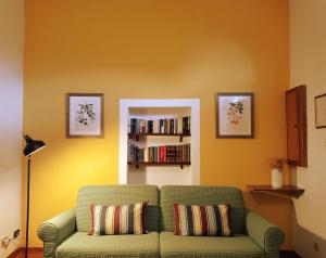sala de estar con sofá verde y estante para libros en Agriturismo Le Case di San Vivaldo, en Montaione