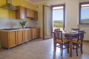 a kitchen with a table and a table and chairs at Agriturismo Baia degli Ulivi in Massa Marittima