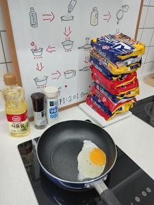 a frying pan with an egg on top of a stove at Athene Motel in Gwangju