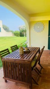 einen Holztisch und Stühle auf einer Terrasse in der Unterkunft 61 Casa Pitta Manau - Casas & Papéis in Porches