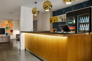 un bar con bancone in legno e alcune bottiglie di alcol di Wyndham Garden Florence a Firenze