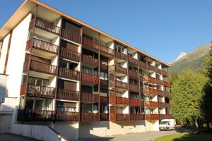 un edificio de apartamentos con balcones y una furgoneta aparcada enfrente en Apartment Arve, en Chamonix-Mont-Blanc