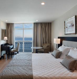 a hotel room with a large bed and a desk at Miramar By Windsor Copacabana in Rio de Janeiro