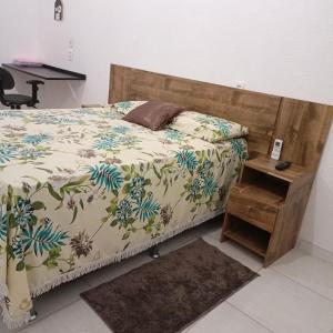 um quarto com uma cama e uma mesa de cabeceira ao lado em Aeroporto House 4 em Macapá
