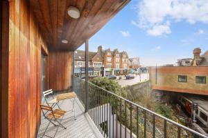 einen Balkon eines Hauses mit Stühlen darauf in der Unterkunft Amazing 2bed flat 10min to Wimbledon tennis courts in London