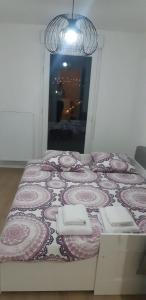 Ce lit se trouve dans un dortoir doté d'une couverture rose et blanche. dans l'établissement La Terrasse - big apartment & terrace 80m2 - metro 17 min from Paris, à Bagneux