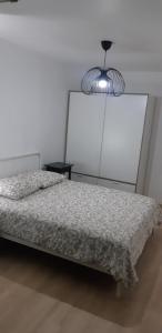 um quarto com uma cama e um lustre em La Terrasse - big apartment & terrace 80m2 - metro 17 min from Paris em Bagneux