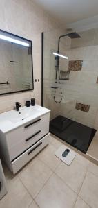 y baño con lavabo blanco y ducha. en Playa Paraiso-Apartment 4 you, en Costa Calma
