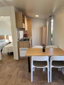 una cucina e una sala da pranzo con tavolo e sedie di Bungalows & Albergue La Playa a Logroño