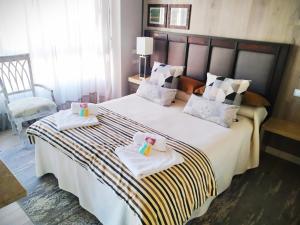 a bedroom with a large bed with two towels at LA CORTE LUXURY ARENA, con terraza a 15 mtr de la playa in Gijón