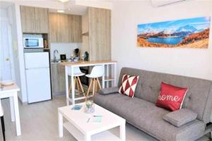 uma sala de estar com um sofá e uma cozinha em 3F 1ª línea de playa con vistas al mar em Calpe