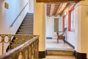 una escalera en un edificio antiguo con una silla en Palazzo Rivola en Bérgamo