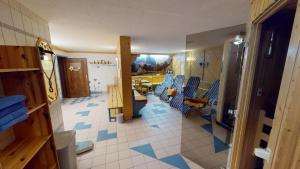 una habitación con sillas azules y una habitación con mesa en Berghotel Presslauer, en Jenig