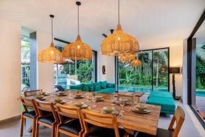 une salle à manger avec une grande table et des chaises en bois dans l'établissement Villa Slide by Bali Superhost, à Ubud